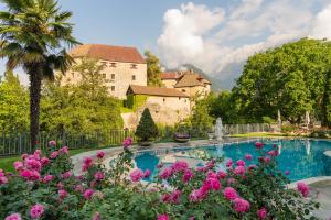 una piscina in un giardino con fiori rosa di Hotel Starkenberg a Scena
