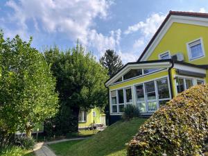 żółty dom z oknami i drzewami w obiekcie AJO Apartments - Alte Donau Terrace Studio - Self-Check-in w Wiedniu