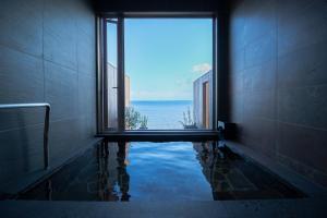 Un baño con una ventana que da al agua. en La-se-ri Resort & Stay - Vacation STAY 63346v, en Himi