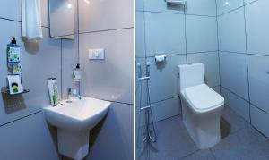 een witte badkamer met toilet en wastafel bij Treebo Airsuite Airport Hotel in Cochin