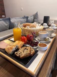 a tray of breakfast foods on a table with orange juice at Olganos VL Luxury Rooms & Suites in Veria
