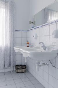 a white bathroom with two sinks and a window at Orkla Gjestebolig in Løkken