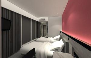 a hotel room with a bed and a red wall at Amaris Hotel Manado in Manado