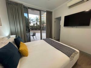 a bedroom with a large bed and a television at Redvue Holiday Apartments in Redcliffe