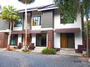 a building with palm trees in front of it at Banyan Resort Bangsaen in Bangsaen