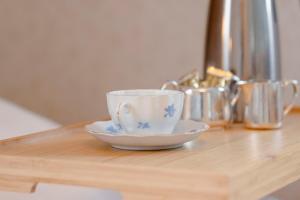 a cup and a saucer on a wooden table at Orkla Gjestebolig in Løkken
