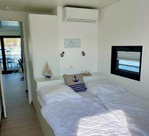 a bedroom with a bed with a pillow on it at Ostsee Hausboot Boltenhagen - WELL Hausboote LP4 in Boltenhagen