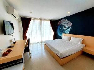 a bedroom with a bed and a desk and a monitor at X GO INN Ao Nang Krabi - โกอินน์ อ่าวนาง กระบี่ in Ban Khlong Haeng