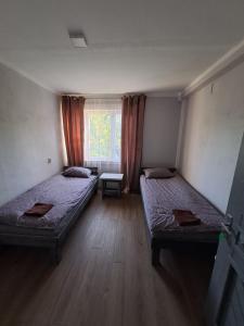 una habitación con dos camas y una ventana en Viesnīca Kārsavā, en Kārsava