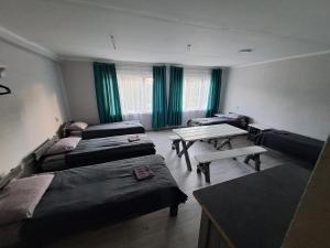 Una habitación con cuatro camas y una mesa dentro. en Viesnīca Kārsavā, en Kārsava