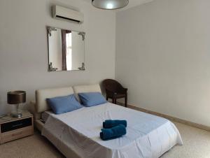 a bedroom with a bed with blue pillows on it at Location, Location, Location in St. Julianʼs