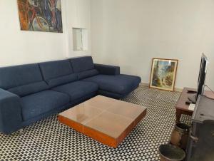 a living room with a blue couch and a coffee table at Location, Location, Location in St. Julianʼs