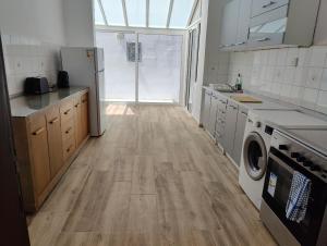 a kitchen with wooden floors and a washer and dryer at Location, Location, Location in St. Julianʼs