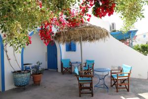 a group of chairs and tables in front of a building at Santorini Seaside Retreat - Flora's Summer Escape in Perissa