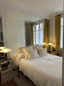 Un dormitorio con una gran cama blanca y dos lámparas. en Luxury and cosy apartment in Paris, 16è Arrondissement, en París