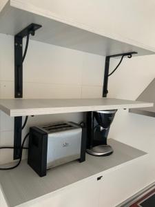 a kitchen shelf with a microwave under a counter at Apartamento Jalama - 2C in Moraleja