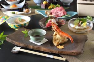einen Tisch mit einem Teller mit Essen und Essstäbchen in der Unterkunft Hotel Binario Saga Arashiyama in Kyoto