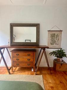 a mirror on top of a wooden dresser in a room at Paradise View Apartment in Knysna