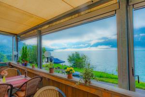 Hotel Wildbach Brienz في برينز: شرفة شاشة مطلة على الماء