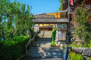 Hotel Wildbach Brienz في برينز: مجموعة من السلالم المؤدية إلى مبنى عليه لافتة