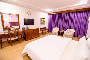 SargodhaHotel One Sargodha的一间卧室，配有一张床和一张带电脑的书桌