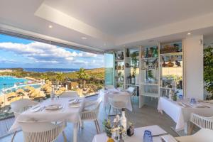 卡萨雷斯Alcazaba Lagoon 512的餐厅设有白色的桌子,享有海景。