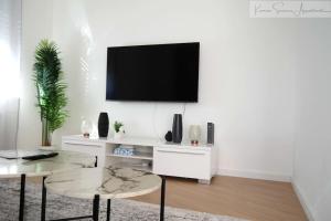 a living room with a tv on a white wall at Ludwigshafen-Bahnhofsresidenz in Ludwigshafen am Rhein