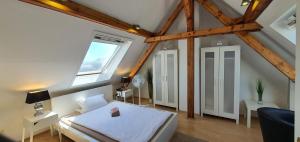 a attic room with a bed and a window at coLodging Mannheim - private rooms & kitchen in Mannheim
