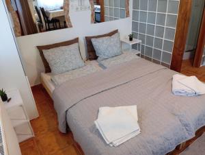 a bedroom with a large bed with towels on it at Tükör apartman Martonvásár in Martonvásár