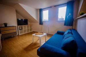 a living room with a blue couch and a tv at Beach à Bâbord - plage 400m, 4 Personnes, Le Havre in Le Havre