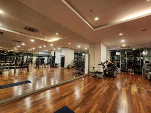 Un gimnasio con suelo de madera y gente haciendo ejercicio en él. en Celestial Heights Hostel featuring Infinity Skypool, en Kuala Lumpur