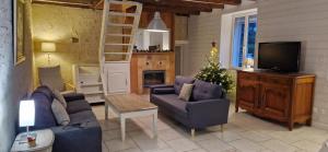 a living room with a couch and chairs and a tv at Ma Demoiselle d'Oé - maison climatisée -3 étoiles in Notre-Dame-dʼOé