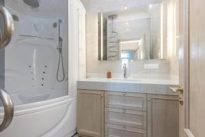 a bathroom with a tub and a sink and a mirror at Riga Old Town 2 Bedroom and Office ArtDeco Apartment with Wifi and TV in Rīga +37 photos