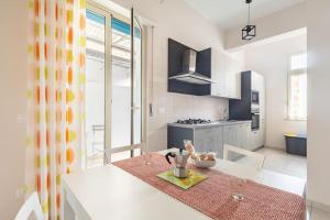 a kitchen with a white table with a counter top at Andiloro Home in Reggio Calabria