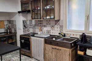 a kitchen with a sink and a stove at Chez Nadège in Marcoussis