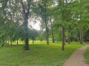 a park with trees and a path in the grass at Chez Nadège in Marcoussis
