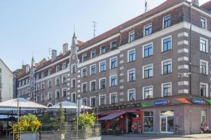 a large brick building in front of a street at Riga Old Town 2 Bedroom and Office ArtDeco Apartment with Wifi and TV in Rīga