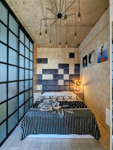 a bedroom with a large bed in a room with large windows at Apartment in bagebi in Tbilisi City
