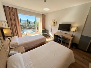 Pokój hotelowy z 2 łóżkami i biurkiem z komputerem w obiekcie Hotel Isla de La Garena w mieście Alcalá de Henares