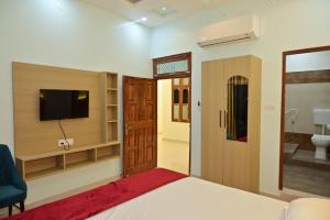 1 dormitorio con 1 cama, TV y baño en Amber Palace, en Ayodhya
