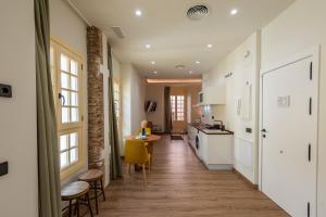 Una cocina con gabinetes blancos y una mesa y sillas. en iloftmalaga Pasaje Chinitas, en Málaga