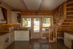 a kitchen with a staircase leading to a sliding glass door at Vėtrungių Namai in Nida +26 photos