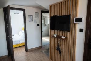 a room with a door with a television and a bedroom at M3-Kraljevo in Kraljevo