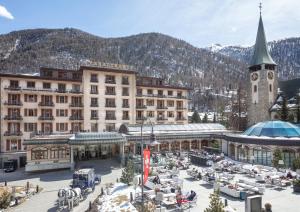 a large building with a clock tower in the snow at Grand Hotel Zermatterhof in Zermatt
