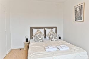 ein Schlafzimmer mit einem Bett mit weißen Laken und Kissen in der Unterkunft Studio lumineux et moderne à Montreuil - II in Montreuil + 5 Fotos