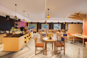 a restaurant with tables and chairs in a room at Ginger Trivandrum in Kazhakuttam