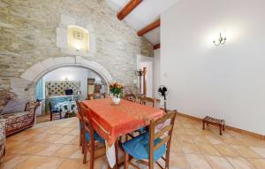 a dining room with a table and a stone wall at Awesome Home In Bollène With Wifi in Bollène
