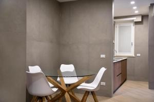 a dining room with a glass table and white chairs at La Maison Latina Guest House in Latina +34 photos