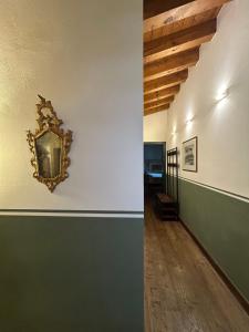 a hallway with green and white walls and a mirror on a wall at Damabianca in Portogruaro