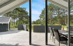 a patio with a table and chairs on a deck at Amazing Home In Hvide Sande With Wifi in Bjerregård +8 photos